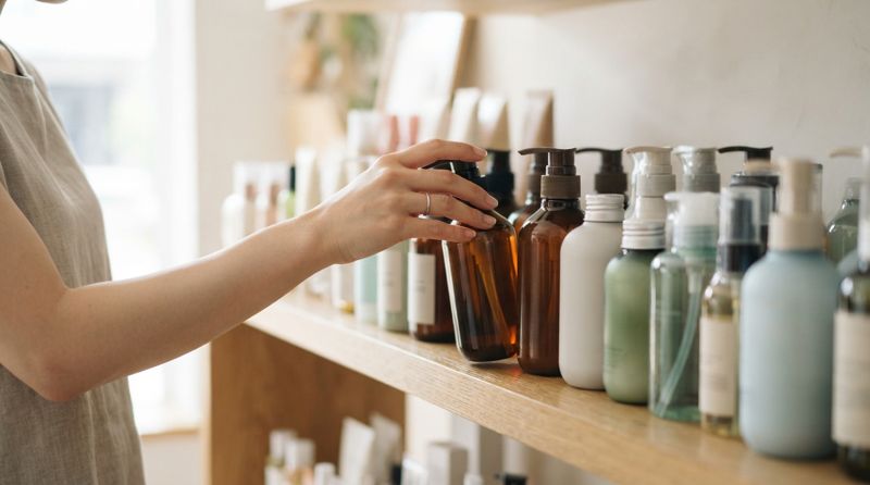 ドラッグストアで発毛剤の商品棚を見比べている様子