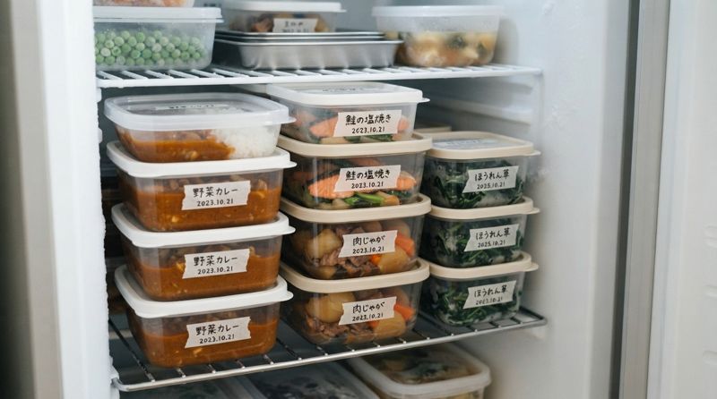 ラベルを貼った食材の保存容器が並ぶ冷凍庫の様子